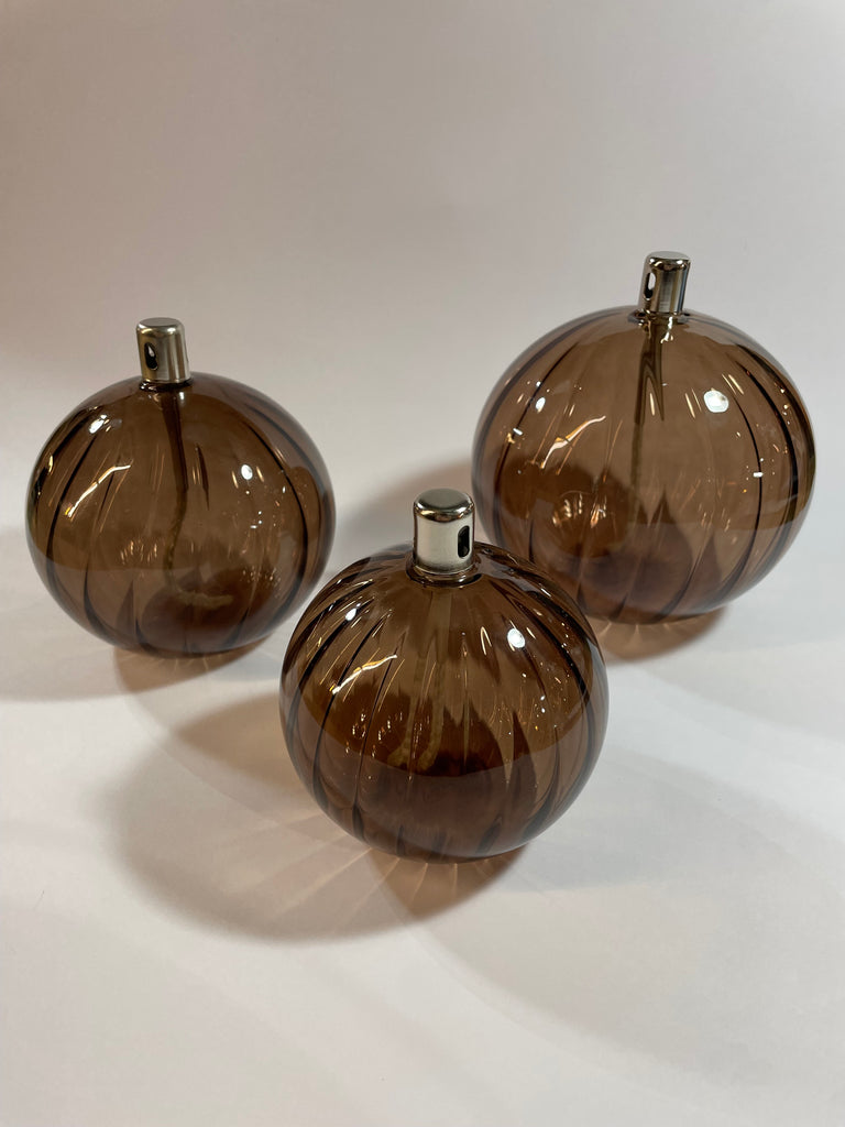 Lampe à huile sphère striée bronze de la marque Bazar de luxe, en verre coloré, fournie sans huile de paraffine.